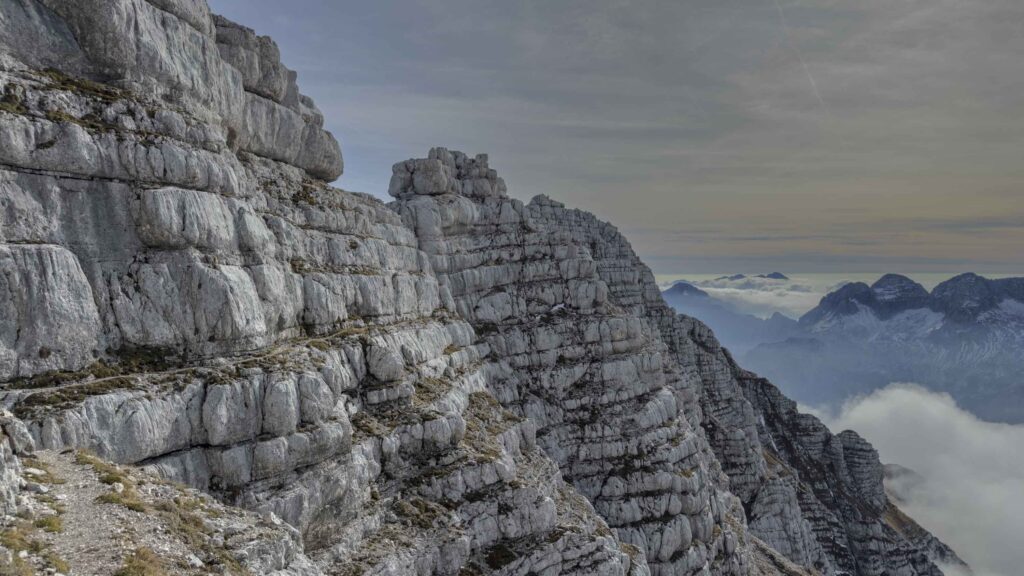 Sentiero roccioso tra maestose montagne con nuvole
